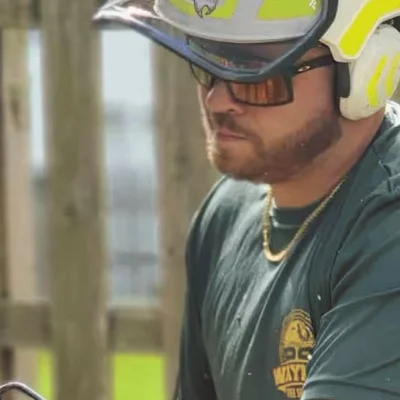 Dylan Ahlert, owner of Wayne’s Tree Service, in a helmet and safety glasses