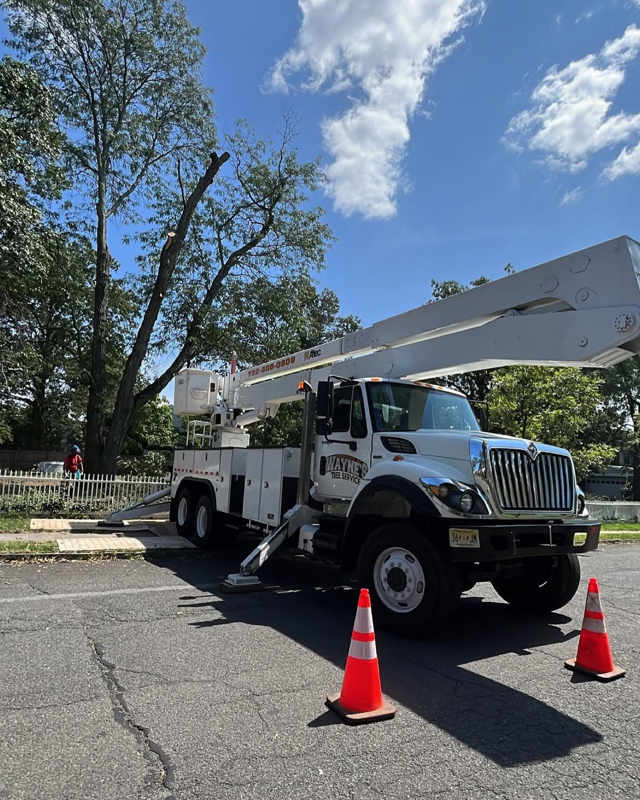 Bucket truck parked on a street with safety cones set out