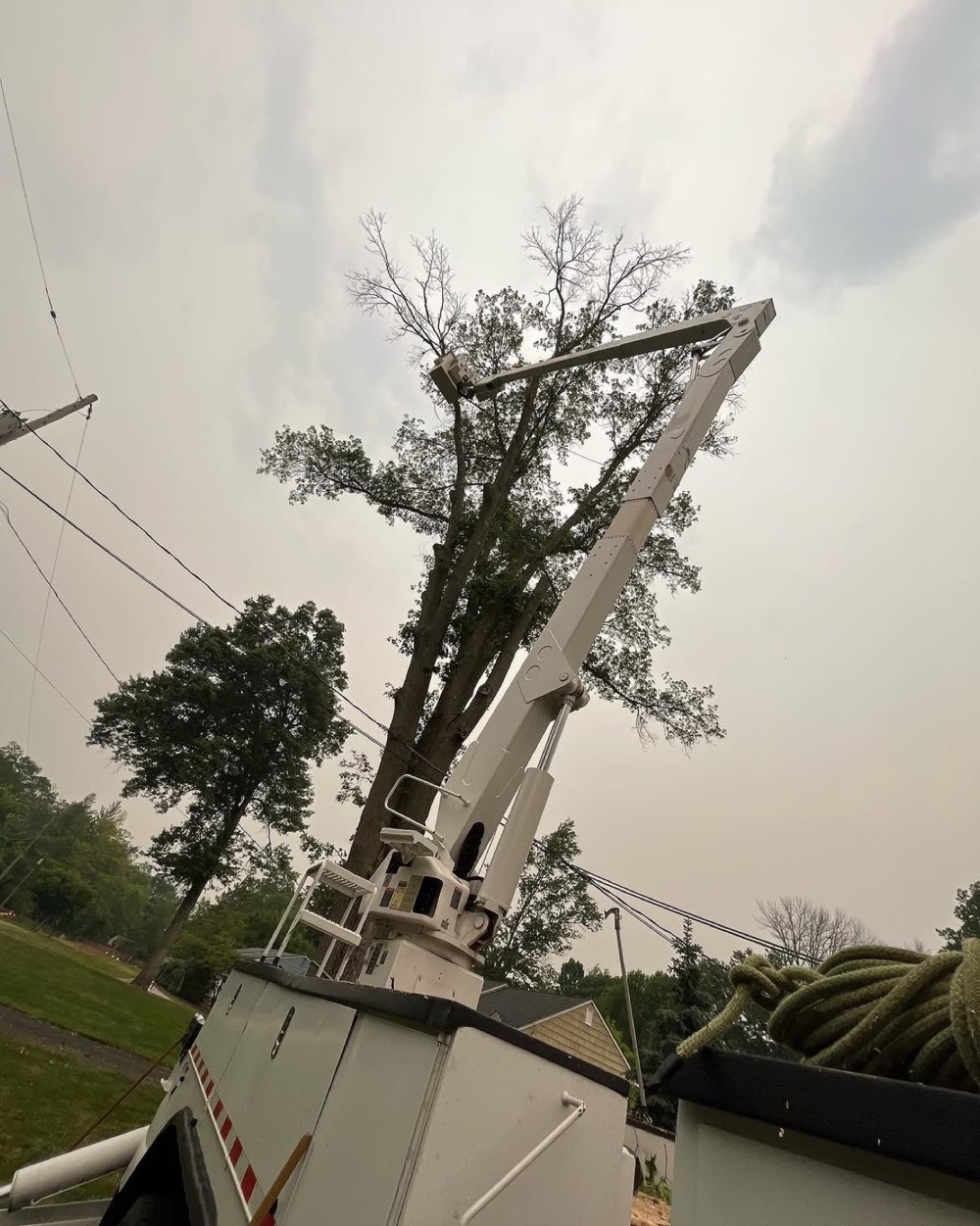 Crane boom raised beside overhead power lines