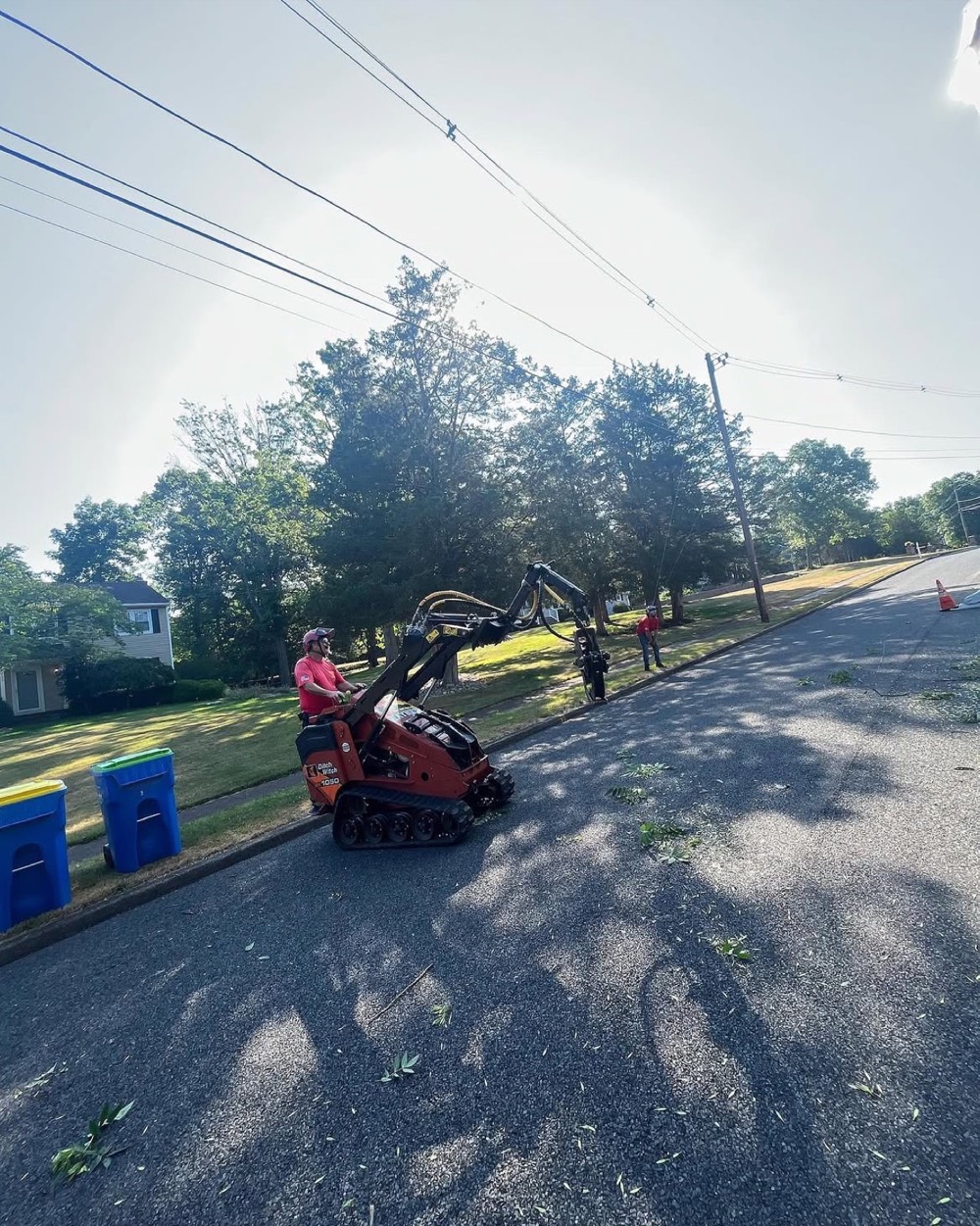 Compact tracked loader being moved along a residential street