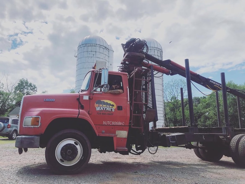 Log truck with a loader arm parked on site